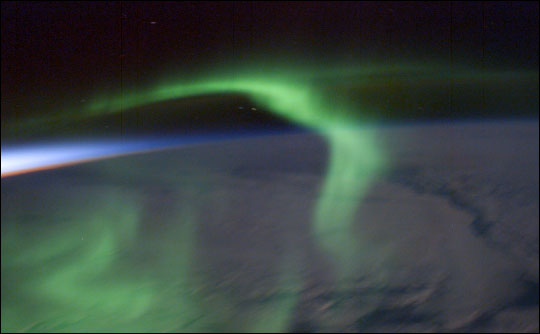 Photograph of green aurora and sunset.