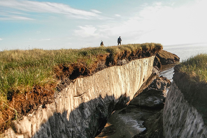 Photo of researchers standing on exposed permafrost.