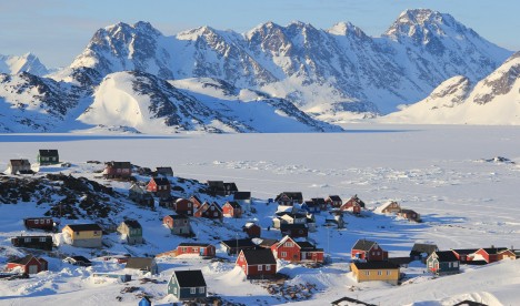 Colorful houses make up the town of Kulusuk in Southeast Greenland. The shores of the fjord are covered by sea ice in the winter. 