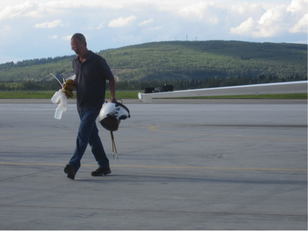  Ryan Ragsdale carries empty water bottles and pilot’s helmet back to hangar after a long day’s flight. (Credit: Valerie Casasanto/NASA) 