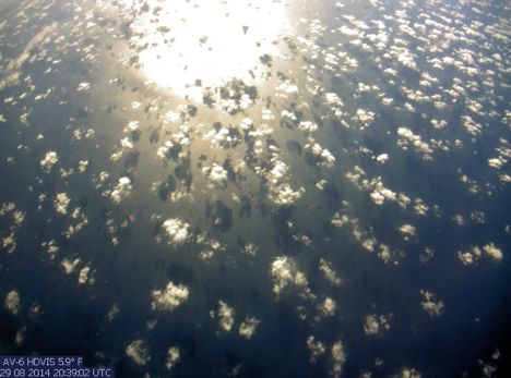 Imagery from AV-6 on the way home from sampling Cristobal; Sunlight reflects off the Atlantic Ocean and clouds cast shadows onto the sea surface