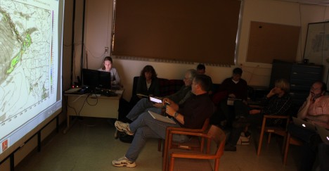 Jen DeHart gives the morning briefing while operations and flight directors and other scientists listen and take notes.